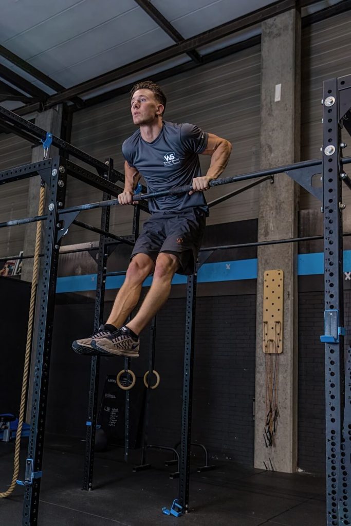 Man doet optrek oefening in sportschool